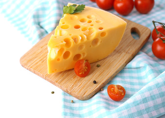Piece of cheese and tomatoes, on wooden board, isolated on