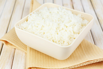 Cooked rice in bowl on wooden background