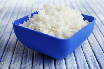 Cooked rice in bowl on wooden background