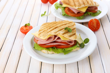 Tasty sandwich with ham on wooden table