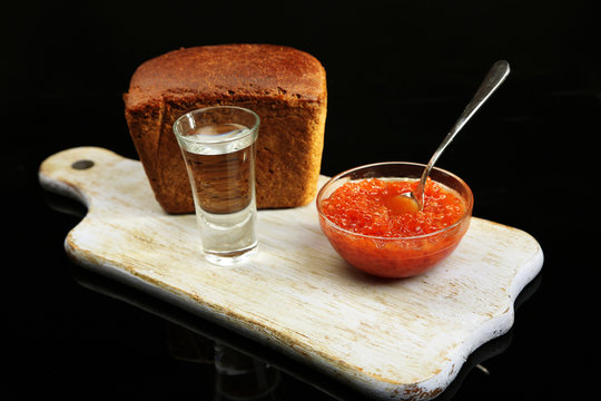 Composition with glass of vodka, red caviar, fresh bread