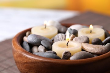 Composition with spa stones, candles on bamboo mat background