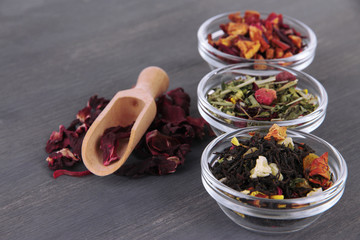 Aromatic dry tea in bowls on wooden background