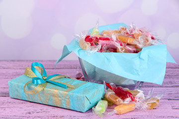Tasty candies in vase with present
