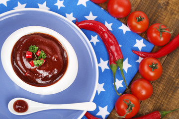Tomato sauce in bowl on wooden table close-up