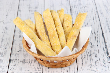 Bread sticks  in wicker basket on wooden background