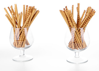 Bread sticks in glasses isolated on white