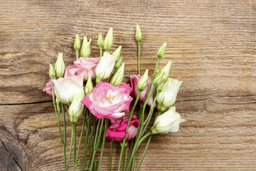Bouquet of pink eustoma flowers on wooden table