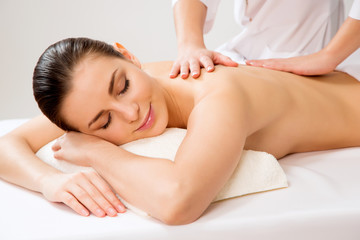 Fototapeta na wymiar Masseur doing massage on the back of woman in the spa salon.