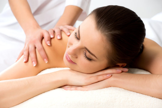 Masseur doing massage on the back of woman in the spa salon.