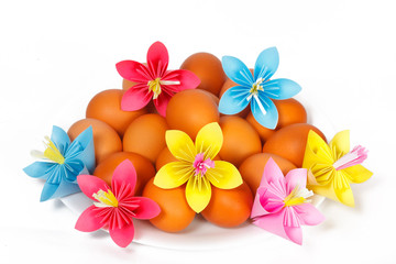 Easter eggs on the plate with a paper flowers