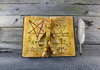 Necronomicon book with straw voodoo doll