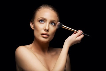 Obraz premium Beautiful woman applying makeup