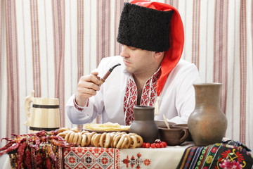 Fototapeta na wymiar Ukrainian Cossack smokes a pipe with tobacco