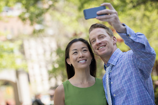 A Couple, A Man And Woman Taking A Selfy With A Smart Phone.