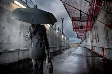 Businessman holding black umbrella on rainy day