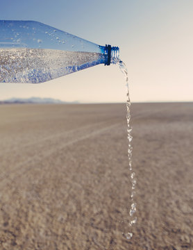 The Landscape Of The Black Rock Desert In Nevada. A Bottle Of Water Being Poured Out. Filtered Mineral Water. 