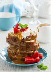Dessert of banana cake with caramel sauce and strawberries.