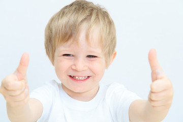 happy little boy with thumbs up on white