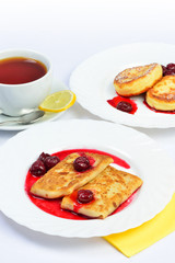 Food of Crepes, cheesecakes with berry sause and cup of tee.