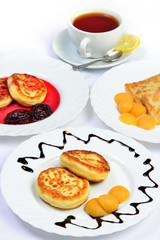 Food of Crepes, cheesecakes with berry sause and cup of tee.