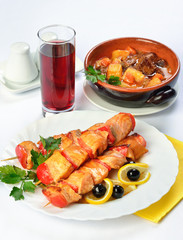 Still life of setout table with soup in ceramic pots, meat on sk