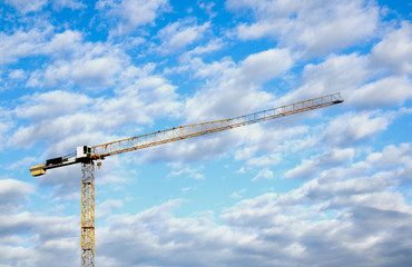Yellow Tower Crane Against Blue Cloud Sky