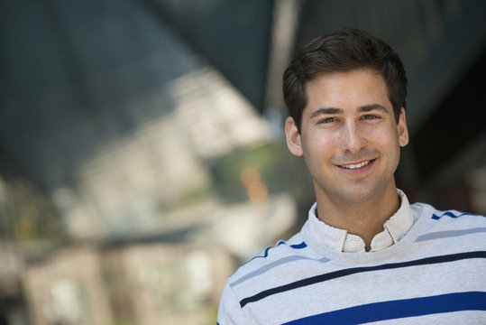 Business People On The Move. A Young Man In A Striped Sweater Looking At The Camera.