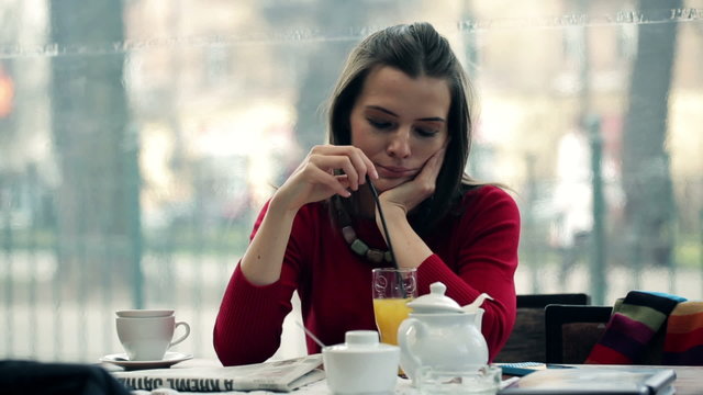 Sad, pensive woman drinking cocktail in cafe