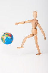 Wood mannequin kick a world globe in disrespect isolated