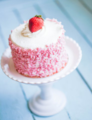 Strawberry cake with white cream on wooden background