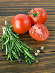 Naklejka na ściany i meble Rosemary bound and tomatoes, peppers on a wooden board