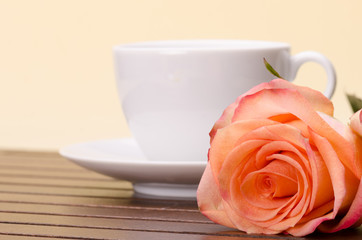 Fototapeta na wymiar Cup of coffee and orange rose