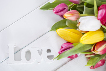 Tulpen auf weissem Holz mit freiem Platz und Schrift Love