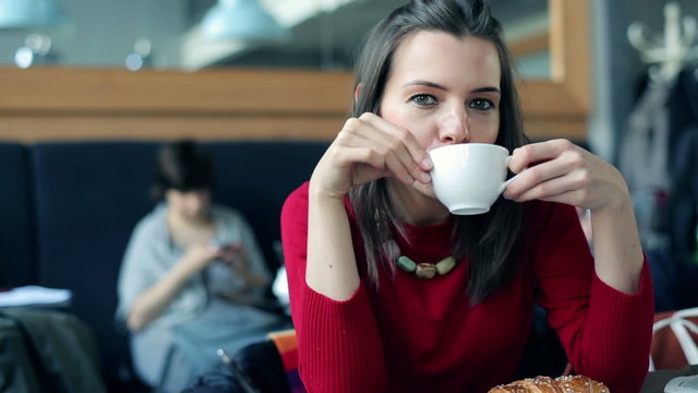 Portrait of pretty, happy young woman drinking coffee