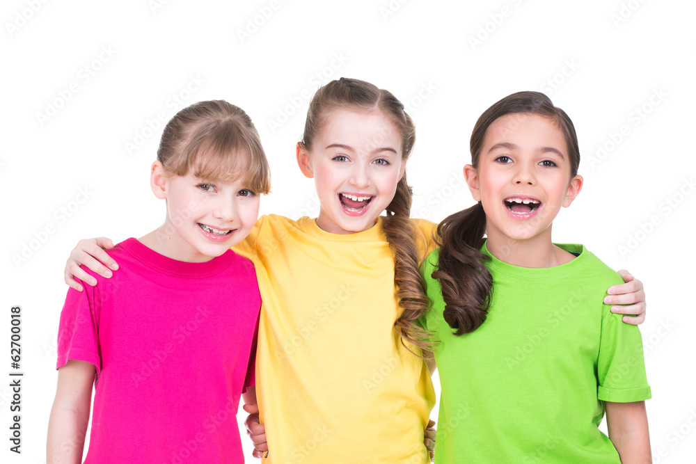 Wall mural Three cute little cute smiling girls in colorful t-shirts.