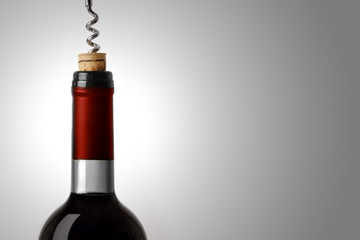 Opening a bottle of red wine, on white background