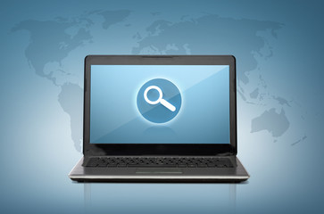 laptop computer with magnifying glass on screen