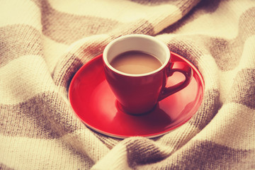 Red cup of the coffee and vintage scarf.