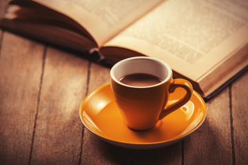 yellow cup of the coffee and vintage book.