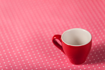 Cup of a coffee on polka dot cover.