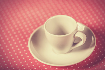 Cup of a coffee on polka dot cover.
