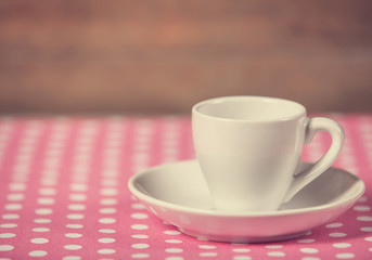 Cup of a coffee on polka dot cover.