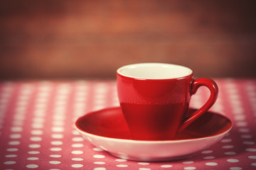 Cup of a coffee on polka dot cover.