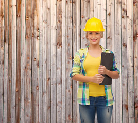 smiling woman in helmet with clipboard