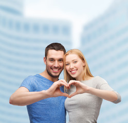smiling couple showing heart with hands