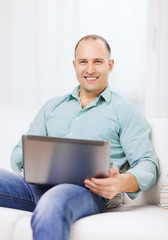 smiling man working with laptop at home