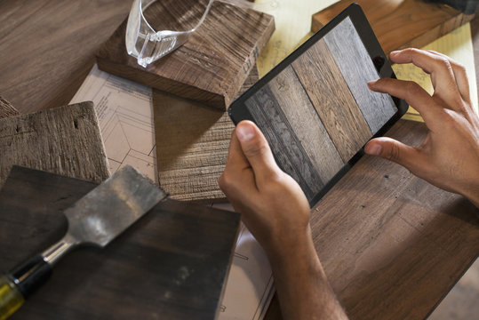 A Young Man In A Workshop. Using A Digital Tablet To Keep Records And Photograph Objects.