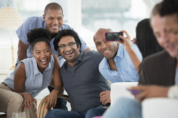 Office Event. A Man Taking A Selfie Of The Group With A Smart Phone.