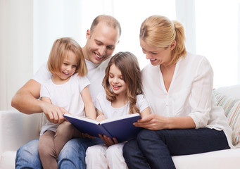 smiling family and two little girls with book